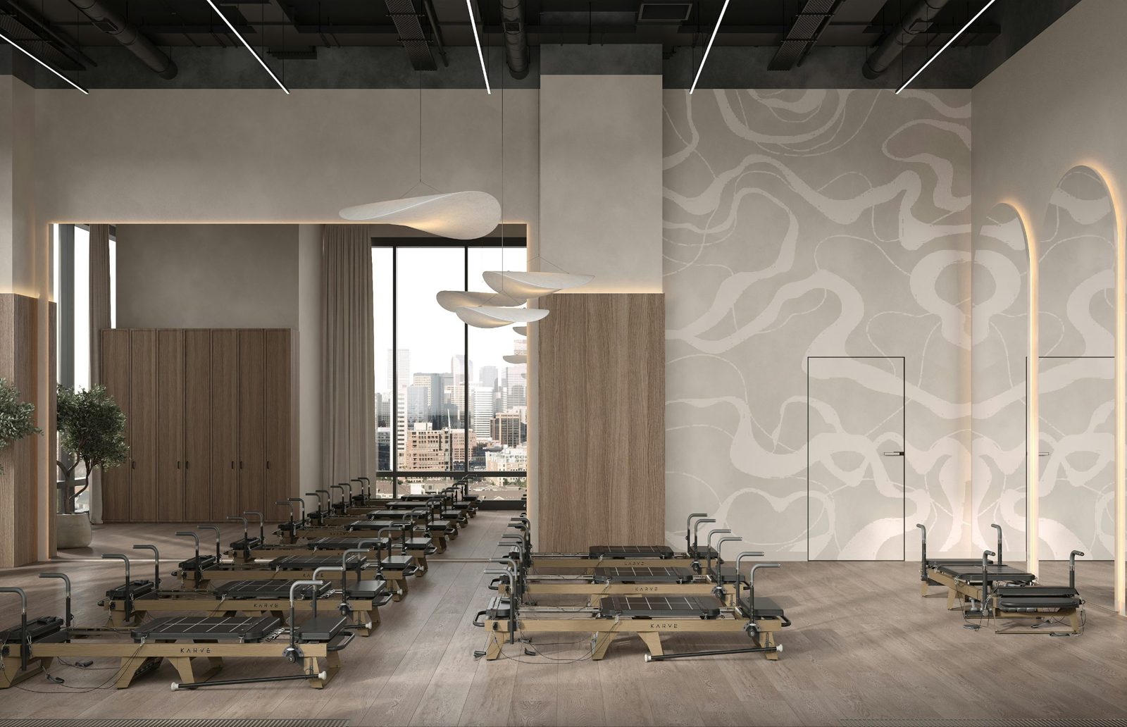 A calm reformer Pilates studio with wood floors, soft lighting and a view of the downtown skyline